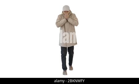 Homme en tenue d'hiver marchant et toussant sur fond blanc. Banque D'Images