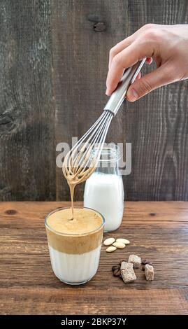 Boisson à la main au café coréen Dalgona à base de lait d'amande et de sucre de canne. Banque D'Images