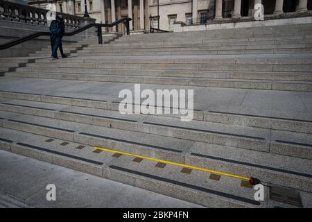 Un mètre ruban est placé contre les marqueurs de mesure impériaux intégrés aux marches menant à la National Portrait Gallery de Trafalgar Square à Londres alors que le Royaume-Uni continue de se verrouiller pour aider à freiner la propagation du coronavirus. Banque D'Images