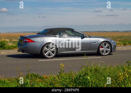 2011 argent Jaguar XKR convertible Auto ; véhicules de circulation automobile, conduite de véhicule sur les routes britanniques, moteurs, conduite sur la route côtière, Southport Merseyside UK Banque D'Images