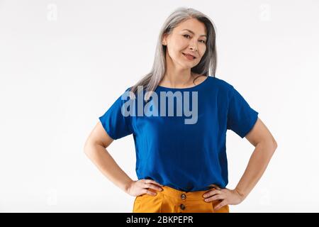 Image d'une femme adulte mûre avec de longs cheveux gris souriant à la caméra isolée sur fond blanc Banque D'Images