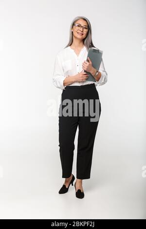 Image d'une femme adulte adulte adulte adulte adulte, portant des lunettes et des vêtements de bureau tenant une pince isolée sur fond blanc Banque D'Images