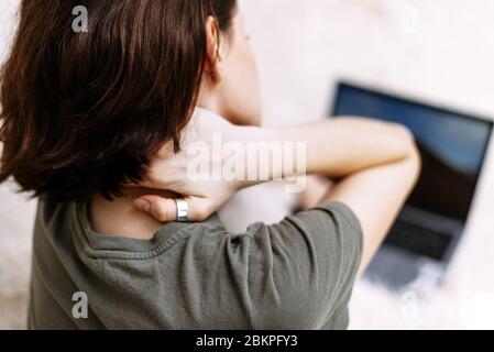 Femme fatiguée massante frottement raideur cou tendu muscles fatigués de travail informatique dans une mauvaise posture sentiment de douleur articulaire épaule arrière douleur, concept de fibromyalgie, vue arrière rapprochée. Banque D'Images