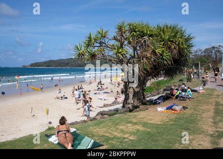 Plage principale de Byron Bay et cape Byron un jour d'été, NSW, Australie, les gens femme bronzant jour de ciel bleu Banque D'Images