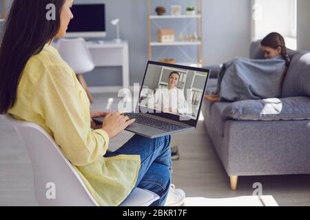 Médecin de famille en ligne. Mère et fille patients consulte avec des médecins vidéo en ligne chat appel webcam portable à la maison. Banque D'Images