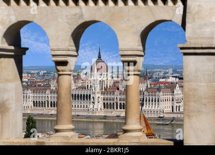 Vue sur le Parlement hongrois à travers les arcades du Bastion des pêcheurs. Budapest, Hongrie, Europe. Banque D'Images