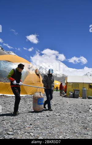 (200505) -- CAMP DE BASE DU MONT QOMOLANGMA, 5 mai 2020 (Xinhua) -- les membres du personnel transportent les déchets de cuisine vers les installations d'élimination des déchets du camp de base du mont Qomolangma, dans la région autonome du Tibet, au sud-ouest de la Chine, le 3 mai 2020. La Chine a lancé un nouveau cycle de mesure sur la hauteur du mont Qomolangma, le sommet le plus élevé au monde. L'équipe de mesure est arrivée au camp de base il y a un mois, ce qui a préparé la mesure prévue en mai. Comme point de départ important et base arrière pour l'alpinisme, le camp de base du Mont Qomolangma est équipé d'installations de base et moi Banque D'Images