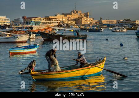 Égypte, Basse-Égypte, côte méditerranéenne, Alexandrie, la Corniche, bateaux de pêche ancrés dans la baie, forteresse de la baie de Qait à l'arrière Banque D'Images