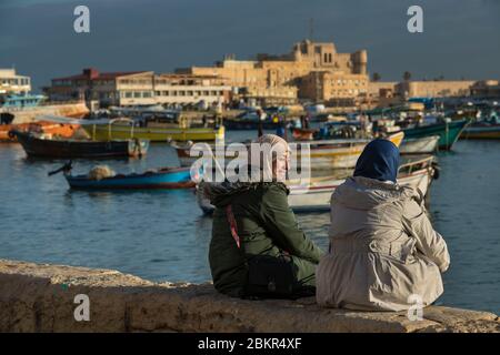 Égypte, Basse-Égypte, côte méditerranéenne, Alexandrie, la Corniche, bateaux de pêche ancrés dans la baie, forteresse de la baie de Qait à l'arrière Banque D'Images