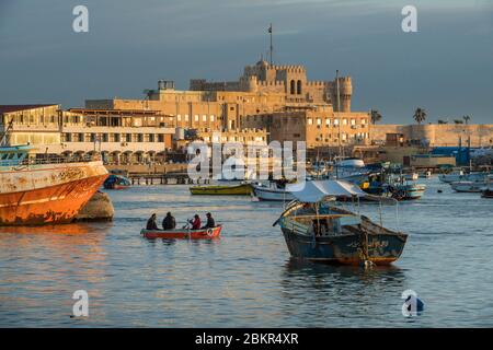 Égypte, Basse-Égypte, côte méditerranéenne, Alexandrie, la Corniche, bateaux de pêche ancrés dans la baie, forteresse de la baie de Qait à l'arrière Banque D'Images