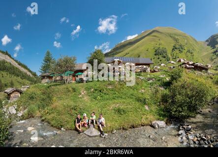 France, haute-Savoie (74), les Contamines-Montjoie, enfants jouant sur le bord du torrent devant la cabane de Miage avec le Mont Vorassay (2287m) et le Col de Tricot (2120m) à droite Banque D'Images