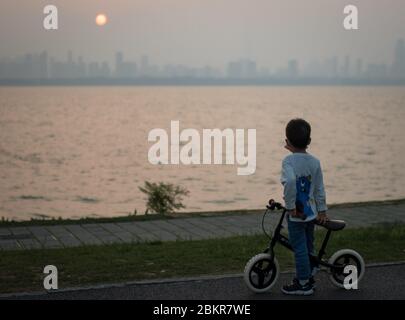 Wuhan, province chinoise de Hubei. 5 mai 2020. Un garçon regarde le coucher du soleil sur le lac Donghu à Wuhan, dans la province de Hubei, au centre de la Chine, le 5 mai 2020. Crédit: Xiao Yijiu/Xinhua/Alamy Live News Banque D'Images