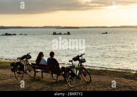 France, Finistère, Plougasnou, touristes cyclistes devant la plage de Saint-Samson au coucher du soleil, le long de la route maritime des vélos Banque D'Images