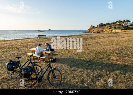 France, Finistère, Plougasnou, touristes cyclistes devant la plage de Saint-Samson au coucher du soleil, le long de la route maritime des vélos Banque D'Images