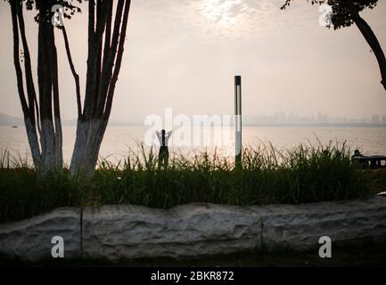 Wuhan, province chinoise de Hubei. 5 mai 2020. Un citoyen regarde le coucher du soleil sur le lac Donghu à Wuhan, province de Hubei, dans le centre de la Chine, le 5 mai 2020. Crédit: Xiao Yijiu/Xinhua/Alamy Live News Banque D'Images