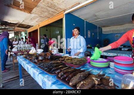 Semporna, Sabah, Malaisie - 26 avril 2020 - femme vendant du poisson grillé à la ville de Semporna Banque D'Images