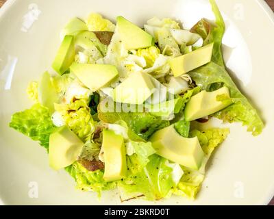 Salade verte fraîche de feuilles de laitue avec morceaux d'avocat Banque D'Images