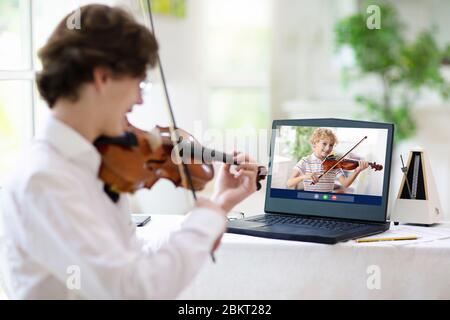Cours de violon en ligne. Professeur et enfant jouent du violon via un ordinateur. Apprentissage à distance à la maison. Arts pour enfant. Enfants avec instrument de musique. Co. Chat vidéo Banque D'Images
