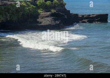 Les vagues en mer approchent du rivage et se transforment en mousse de mer. La photo des vagues approche le rocher et la rive. Les eaux de l'océan Indien sont lavées de clave noire Banque D'Images