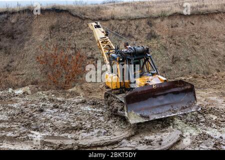 Bulldozer à chaînes sur route boueuse. Banque D'Images