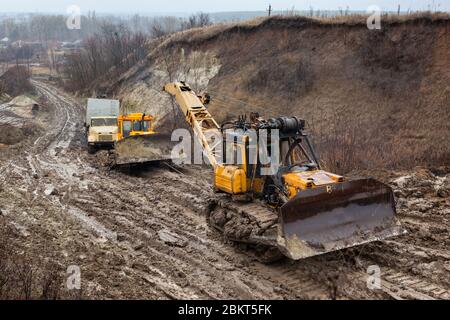 Bulldozer à chaînes sur route boueuse. Banque D'Images