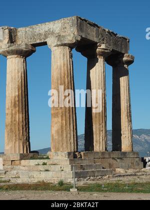 Colonnes doriques du temple archaïque à Apollon à Corinthe, Péloponnèse, Grèce contre un ciel bleu Banque D'Images