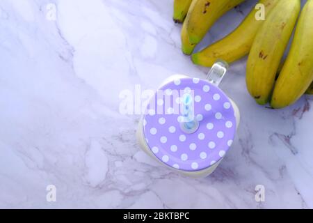 milk-shake de banane dans un pot et banane sur la table Banque D'Images