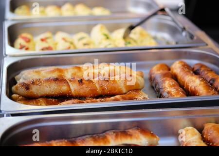 Les pains de pain aux graines de sésame dans des contenants métalliques sont vendus lors d'un festival appétissant de cuisine. Restaurant de rue. Banque D'Images