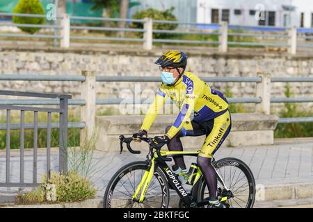 Homme à vélo, portant un masque, comme protection contre la pandémie Covid-19 Banque D'Images