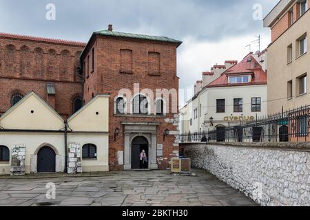 Femme célibataire quittant la synagogue Stara dans le quartier juif de Cracovie, Pologne Banque D'Images