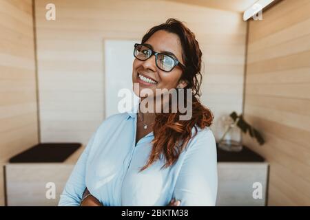 Jeune femme d'affaires avec lunettes souriant au bureau. Bonne femme de direction regardant la caméra. Banque D'Images