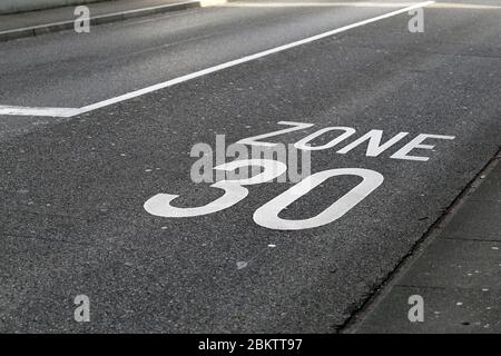 Allée asphaltée en Suisse avec limite de vitesse de 30 km/h. Limite de vitesse marquée sur route avec le texte « zone 30 ». Zone urbaine dans une ville suisse. Image couleur. Banque D'Images