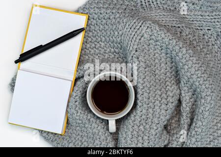 Plat de travail confortable espace de travail avec café chaud, ordinateur portable et accessoires d'écriture. Travail à la maison. Écriture. Concept chaud par temps froid. Banque D'Images
