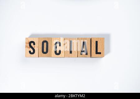 Texte ' SOCIAL ' fait de cube en bois sur fond blanc. Banque D'Images