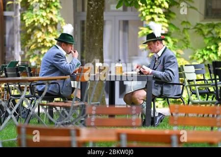 Les ministres de l'économie des pays s'efforcent d'ouvrir l'industrie hôtelière dans un corridor du 9 au 22 mai. Archive photo: Deux hommes traditionnels, hommes en costume bavarois, assis dans un jardin de bière avec bière et saucisse blanche. Sur le terrain de la Herrmannsdorfer Landwerkstaetten - une ferme biologique à Glonn (sud-est de Muenchen). Visite du Prince de Galles et de la duchesse de Cornouailles en Bavière le 10 mai 2019. Â | utilisation dans le monde entier Banque D'Images