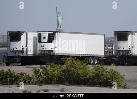 Brooklyn, États-Unis. 05e mai 2020. La Statue de la liberté se tient derrière des camions frigorifiques qui sont utilisés dans le cadre d'une morgue temporaire pour les victimes du coronavirus à New York le mardi 5 mai 2020. La pandémie du coronavirus COVID-19 touche 212 pays dans le monde, soit plus de 250,000 000 décès. Photo de John Angelillo/UPI crédit: UPI/Alay Live News Banque D'Images