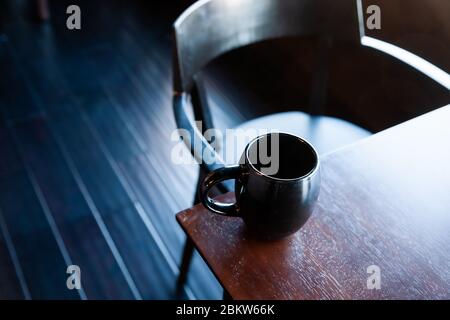 Une tasse de café assis sur une table en bois Banque D'Images