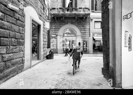 FLORENCE, ITALIE - 13, MARS 2018 : photo en noir et blanc d'un homme italien à vélo dans les rues étroites de Florence, Italie Banque D'Images