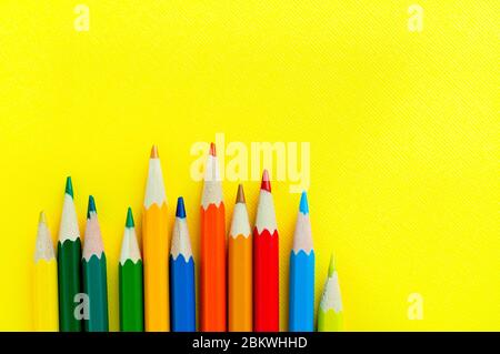 Crayons de couleur bois sur fond jaune vif. Des matériaux pour la créativité des enfants. Placer pour le texte Banque D'Images