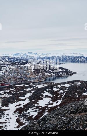 Ville de Qaquortoq au Groenland avec des chaînes de montagnes visibles derrière. Banque D'Images