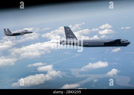 Un B-52 Stratoforteresse et un F-15 Strike Eagle survolent le sud de la Louisiane, le 1er mai 2020. Des unités de la 159e Escadre de chasseurs, de la 307e Escadre de bombardes et de la 2e Escadre BW ont survolé des établissements de santé de la Nouvelle-Orléans et de Baton Rouge, en Louisiane, pour honorer les travailleurs essentiels qui combattent la pandémie COVID-19. (ÉTATS-UNIS Photo de la Force aérienne par le premier Airman Lillian Miller) Banque D'Images