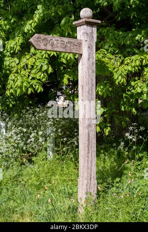 Panneau de chemin de randonnée en bois dirigeant les marcheurs vers un sentier public à Swinbrook, les Cotswolds, Oxfordshire, Royaume-Uni Banque D'Images