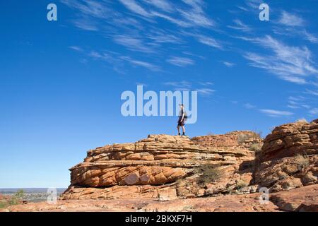 Randonneur sur un affleurement en grès sur la promenade du plateau de Kings Canyon, territoire du Nord, Australie Banque D'Images