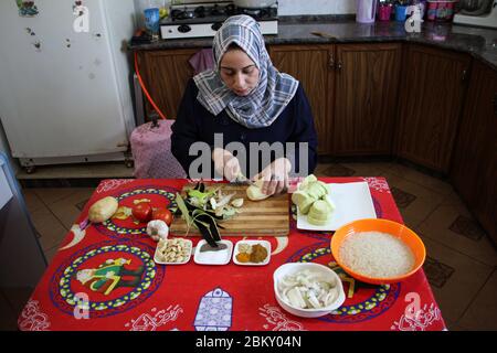 Gaza. 4 mai 2020. Hanady Tawahin, cuisine dans la cuisine de Deir al-Balah, dans le centre de la bande de Gaza, 4 mai 2020. Dans la cuisine de sa maison dans la ville centrale de la bande de Gaza, Deir al-Balah, Hanady Tawahin prépare chaque jour différents types de nourriture et de desserts pour les clients. Cette femme de 31 ans a utilisé son talent pour cuisiner des plats palestiniens traditionnels pour gagner de l'argent pendant le Saint mois de jeûne du Ramadan. POUR ALLER AVEC: 'Feature: Les femmes palestiniennes cuisent pour gagner de l'argent pour la vie pendant le Ramadan' crédit: Rizek Abdeljawad/Xinhua/Alamy Live News Banque D'Images