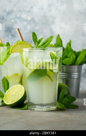 Deux limonades ou mojito maison avec citron vert, menthe et glaçons dans un verre sur une table en pierre légère. Boisson fraîche d'été. Banque D'Images