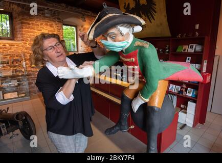 Bodenwerder, Allemagne. 04e mai 2020. Claudia Erler, directrice du musée, met un masque facial sur une figure du Baron von Münchhausen dans le Münchausen-Museum Bodenwerder. Le "mensonge baron" Münchhausen, qui roule sur un canon, est connu dans le monde entier comme une figure littéraire ou héros de film. Le personnage artistique est basé sur la personnalité historique Hieronymus Carl Friedrich Baron von Münchhausen, né il y a 300 ans le 11 mai 1720 à Bodenwerder sur le Weser. Le célèbre Baron de Münchhausen est commémoré. Crédit : Julian Strattischulte/dpa/Alay Live News Banque D'Images