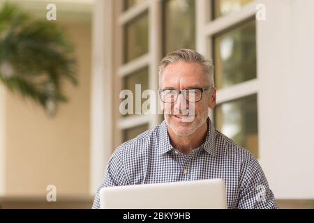 Homme mûr et ajusté assis à l'extérieur de la photo de stock Banque D'Images
