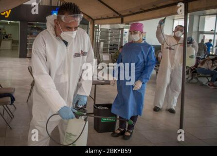 Tijuana, Mexique. 02e mai 2020. Les membres du groupe 'Covid Busters' effectuent des mesures de désinfection contre la propagation de Covid-19 dans une gare routière. Le groupe a pris le nom de 'Ghostbusters' dans les films américains et prévoit de désinfecter des endroits dans la ville bordant les Etats-Unis où de nombreuses personnes se rassemblent. Les hommes ne prennent pas d'argent pour ce travail. Ce sont des citoyens, des amis et des pères de famille qui font ce service par amour et soin de leur ville, comme ils écrivent sur Facebook. Crédit : Omar Martínez/dpa/Alay Live News Banque D'Images