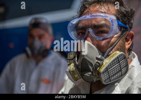 Tijuana, Mexique. 02e mai 2020. Un membre du groupe 'Covid Busters' portant des lunettes en plastique et un masque facial s'arrête brièvement sur le bord d'une campagne de désinfection contre la propagation de Covid-19 le groupe s'est nommé 'Ghostbusters' en référence aux films américains et prévoit de désinfecter des endroits dans la ville bordant le USA où de nombreuses personnes se rassemblent. Les hommes ne prennent pas d'argent pour ce travail. Ce sont des citoyens, des amis et des pères de famille qui font ce service par amour et soin de leur ville, comme ils écrivent sur Facebook. Crédit : Omar Martínez/dpa/Alay Live News Banque D'Images