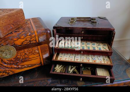 Ensemble de mahjong antique avec tiroirs partiellement ouverts exposant des tuiles blanches avec des caractères chinois, des compteurs, et des pièces de jeu; mah-jong, mah-jongg. Banque D'Images